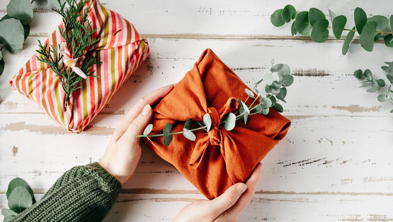 Person holding gift wrapped in fabric